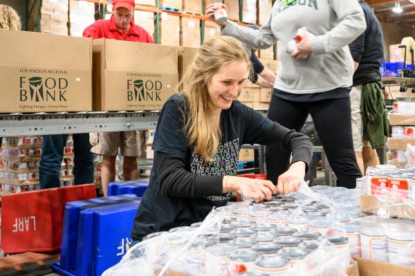 Local volunteer Ingrid Silakousky from Orange, California lends a hand unwrapping canned goods.